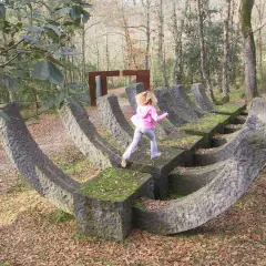 Bambini giocano su una scultura in pietra nel **Chianti Sculpture Park**.