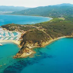 Vista aerea di una punta con un porto turistico pieno di barche, case e vegetazione. Un luogo incantevole dove la punta ala cosa vedere.