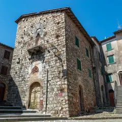 Antiche case in pietra a Montieri, cosa vedere: un vicolo con scale, balcone e finestre verdi.