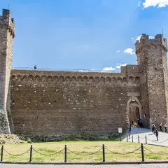 La fortezza medievale con torri imponenti e mura di pietra, un luogo dove il tempo sembra essersi fermato.