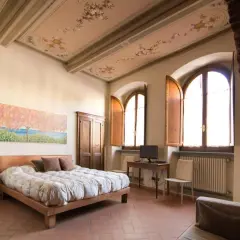 Camera da letto con soffitto affrescato, letto comodo e vista su Arezzo dove dormire.