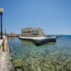 Il lungomare di Livorno con il Bagni Pasquali, un edificio giallo affacciato sul mare cristallino.