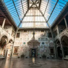 Interno di ville medicee visitabili con affreschi, un grande lampadario e tetto in vetro.