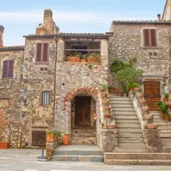 Un pittoresco borgo toscano con case in pietra, scale in terracotta e piante rigogliose.