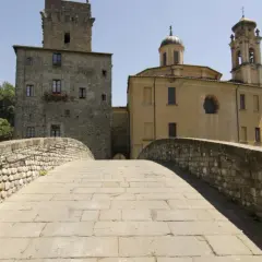 Ponte in pietra a Pontremoli, con torre medievale e campanile. Un luogo incantevole per scoprire cosa fare a Pontremoli.