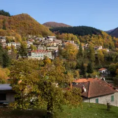 Case colorate e boschi autunnali abbracciano il borgo di Badia Prataglia, un incantevole paesaggio appenninico.