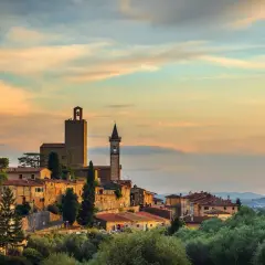 Borgo toscano al tramonto, con torri medievali e case in pietra. Un luogo incantevole da scoprire: cosa vedere a Vinci.