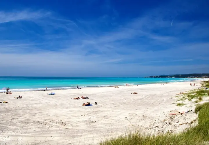 Vada Spiagge Bianche: sabbia chiara, mare turchese e cielo azzurro. Persone rilassate al sole su questa splendida costa.