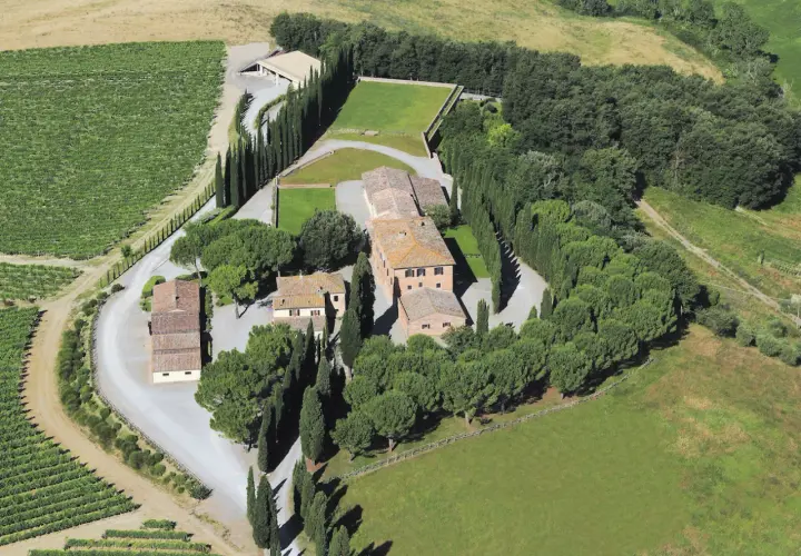 Vista aerea della tenuta Altesino winery, con vigneti, cipressi e casali in pietra.