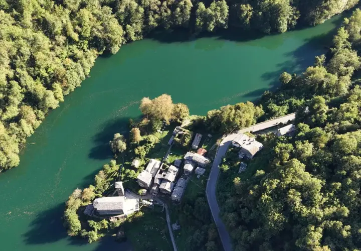 Un borgo incantevole, l'isola santa delle Alpi Apuane, abbracciato da un lago smeraldo e boschi rigogliosi.