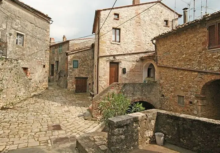 Un vicolo acciottolato a Semproniano, con case in pietra e archi. Un luogo incantevole da esplorare per scoprire cosa vedere.