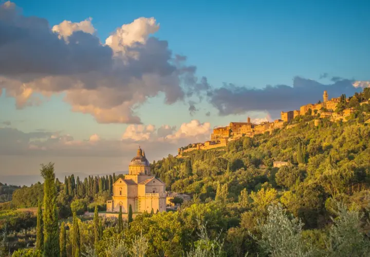 La chiesa rinascimentale e il borgo medievale, incastonati tra colline verdi, mostrano dove si trova Montepulciano al tramonto.