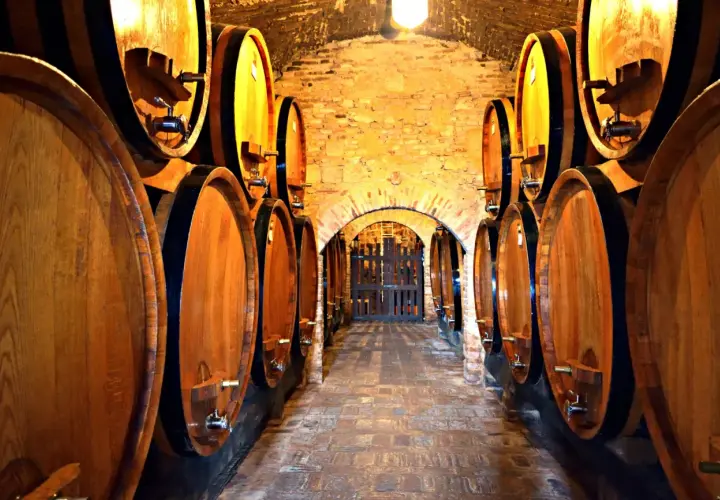 Corridoio di cantine in Toscana, con botti di legno che maturano il vino.