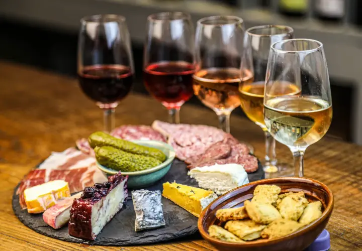 Calici di vini naturali a Firenze, accompagnati da salumi, formaggi e sottaceti. Un'esperienza gustosa.