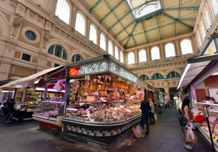 Mercato coperto con banchi di salumi e formaggi, un angolo del buon gusto tra i più bei mercati di Toscana.
