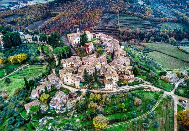 Un borgo medievale tra i più belli del Chianti, con tetti in cotto e vigneti circostanti.