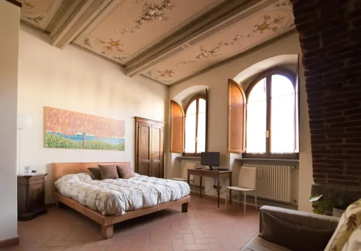 Camera da letto con soffitto affrescato, letto comodo e vista su Arezzo dove dormire.