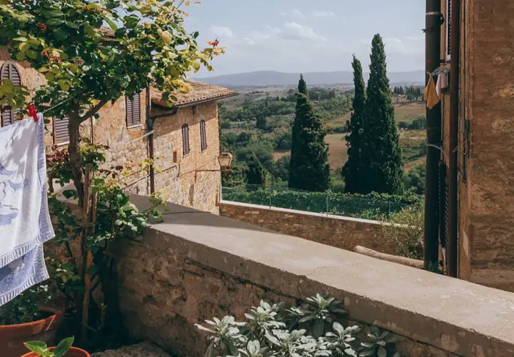 Capalbio, famosa per i suoi borghi medievali e i paesaggi toscani, con panni stesi al sole e cipressi che svettano.