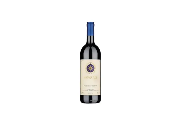 A bottle of Sassicaia wine with a blue cap and a cream-colored label featuring a compass rose.
