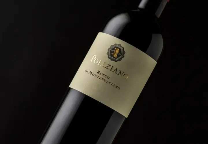 Bottiglia di vino rosso Poliziano, azienda agricola di Montepulciano, con etichetta color crema e scritte dorate.