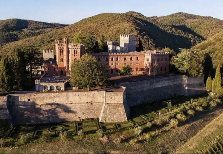 Il Castello di Brolio, imponente fortezza in mattoni rossi, domina le colline toscane, circondato da vigneti e cipressi.