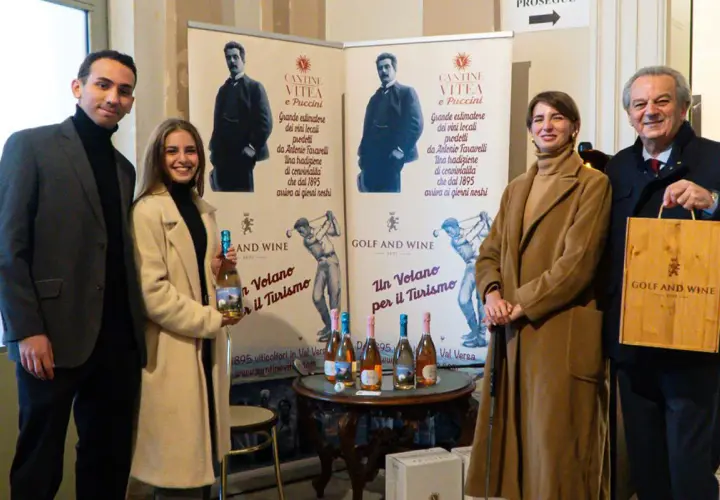 Antonio Faravelli, un nome legato alla tradizione vinicola. Quattro persone sorridono davanti a banner che celebrano la storia di Cantine Vitea e Puccini.