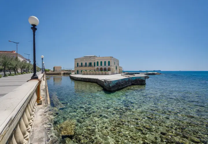 Il lungomare di Livorno con il Bagni Pasquali, un edificio giallo affacciato sul mare cristallino.