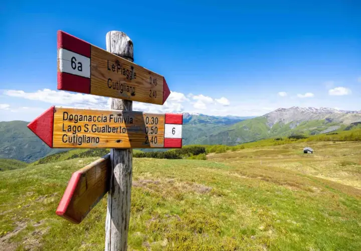 Segnavia in legno sui sentieri dei borghi della montagna pistoiese, con indicazioni per Cutigliano e Doganaccia.