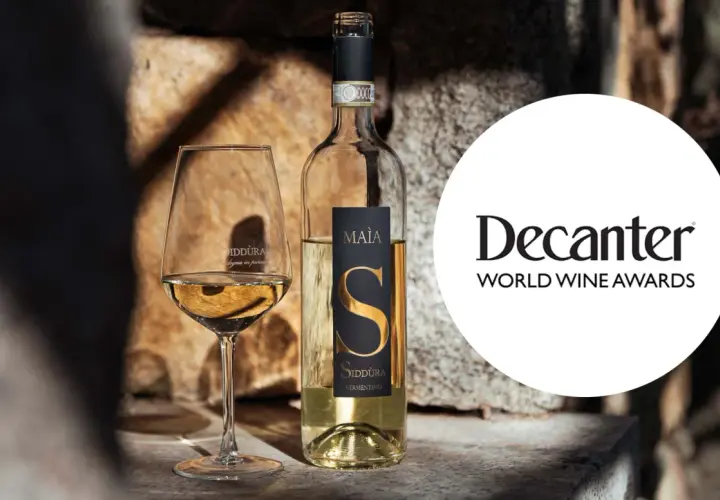 Calice e bottiglia di Vermentino Siddùra Maia, tra i migliori vini bianchi italiani premiati da Decanter World Wine Awards.