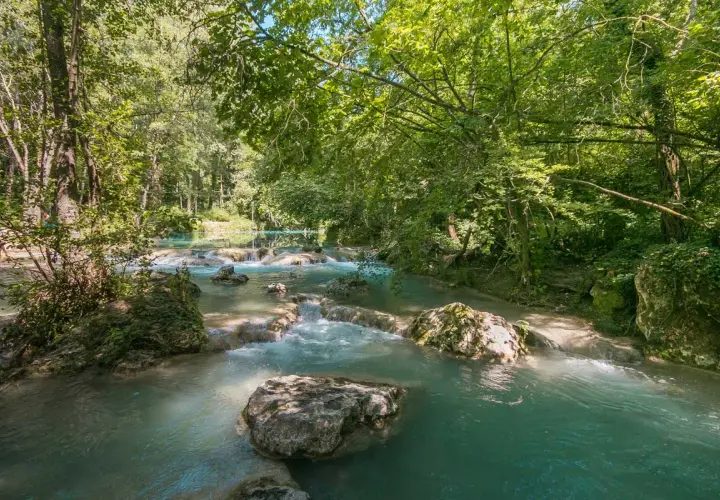 Acque turchesi scorrono tra rocce e vegetazione lussureggiante nel **Val d'Elsa**. Un angolo di paradiso naturale.