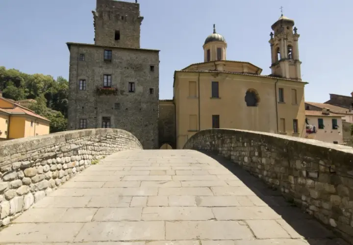 Ponte in pietra a Pontremoli, con torre medievale e campanile. Un luogo incantevole per scoprire cosa fare a Pontremoli.