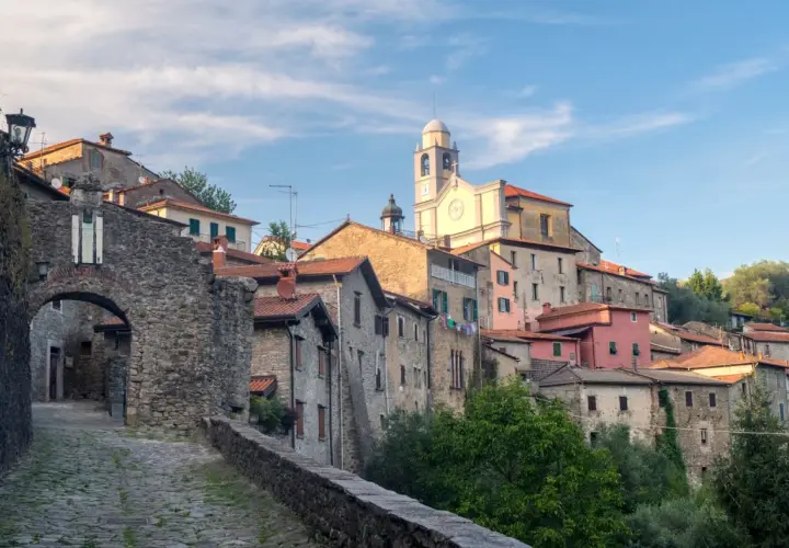 Antico borgo in pietra della Lunigiana, dove si trova un'antica porta d'accesso e una chiesa con campanile.