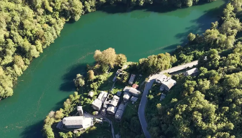 Un borgo incantevole, l'isola santa delle Alpi Apuane, abbracciato da un lago smeraldo e boschi rigogliosi.