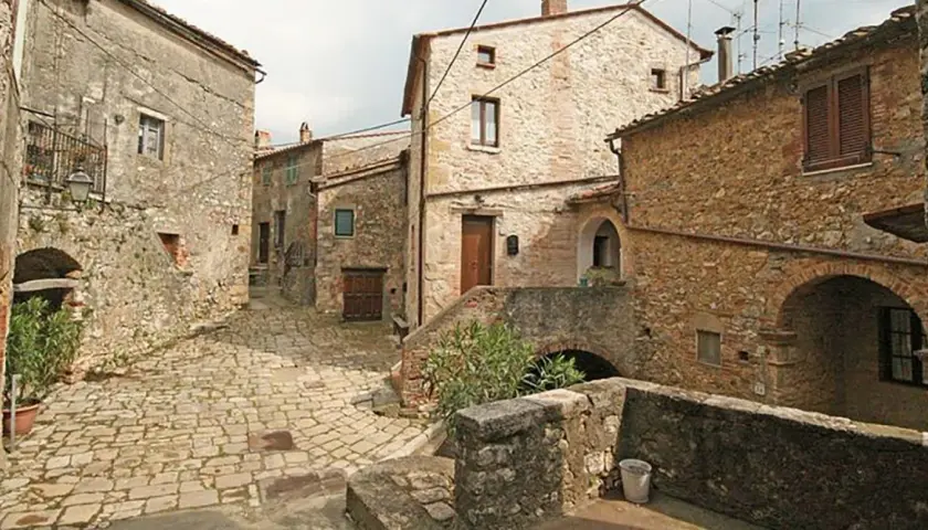 Un vicolo acciottolato a Semproniano, con case in pietra e archi. Un luogo incantevole da esplorare per scoprire cosa vedere.