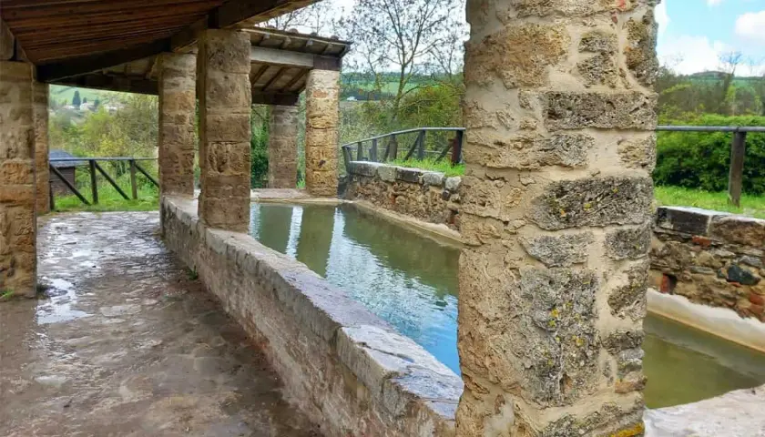 Antiche vasche d'acqua nel centro storico di San Casciano dei Bagni, con colonne in pietra e tettoia in legno.