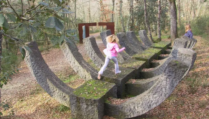 Bambini giocano su una scultura in pietra nel **Chianti Sculpture Park**.