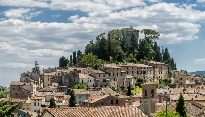 Panoramica di Cetona, un borgo toscano con case in pietra e tetti in cotto, dominato da una torre antica. Cosa vedere in questo incantevole paesaggio.