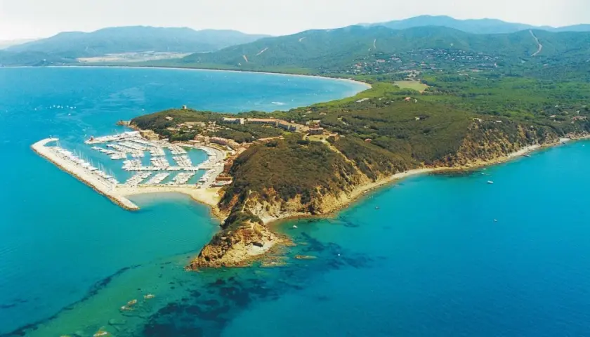 Vista aerea di una punta con un porto turistico pieno di barche, case e vegetazione. Un luogo incantevole dove la punta ala cosa vedere.