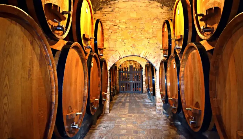 Corridoio di cantine in Toscana, con botti di legno che maturano il vino.
