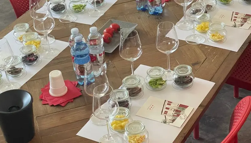 Degustazione al podere conca: bicchieri, vasetti con campioni e bottiglie d'acqua pronti per un'esperienza sensoriale.