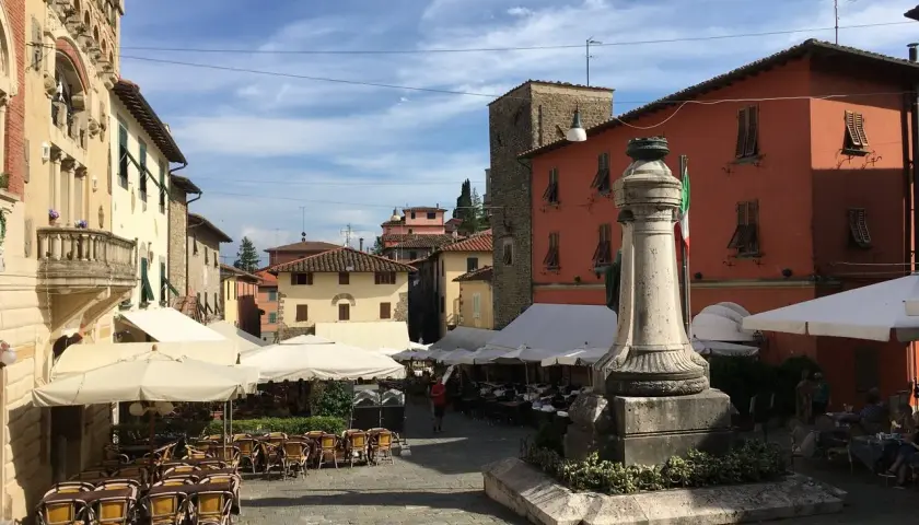 Piazza di Montecatini Alto, con tavolini all'aperto e un monumento. Un assaggio di cosa vedere a Montecatini Alto.