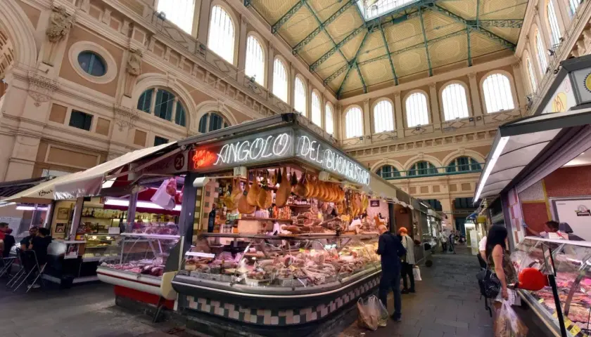 Mercato coperto con banchi di salumi e formaggi, un angolo del buon gusto tra i più bei mercati di Toscana.