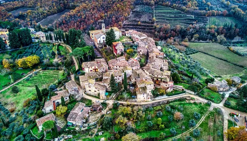 Un borgo medievale tra i più belli del Chianti, con tetti in cotto e vigneti circostanti.