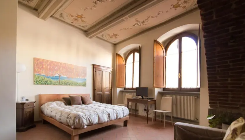 Camera da letto con soffitto affrescato, letto comodo e vista su Arezzo dove dormire.