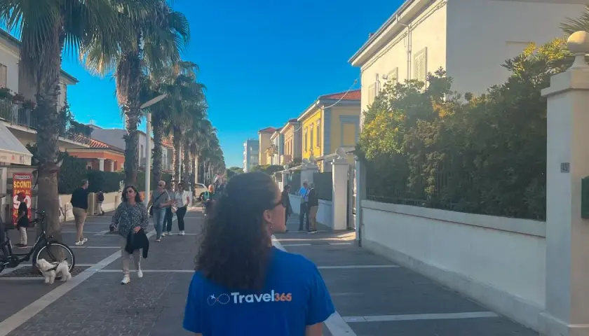 Passeggiata nel centro storico di Marina di Cecina, tra palme e case colorate.
