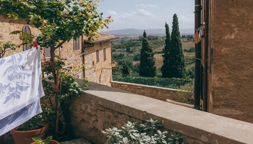Capalbio, famosa per i suoi borghi medievali e i paesaggi toscani, con panni stesi al sole e cipressi che svettano.
