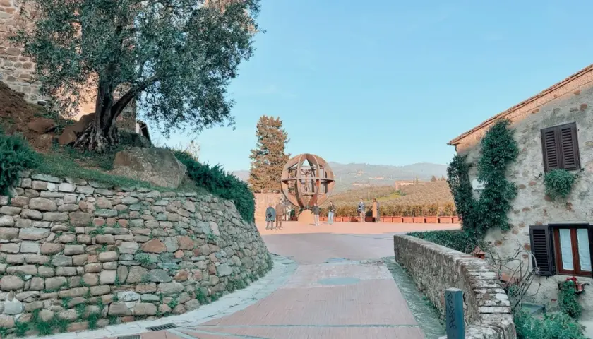 Vinci cosa vedere: un'installazione artistica a forma di globo, un ulivo secolare e case in pietra con vista sulle colline toscane.
