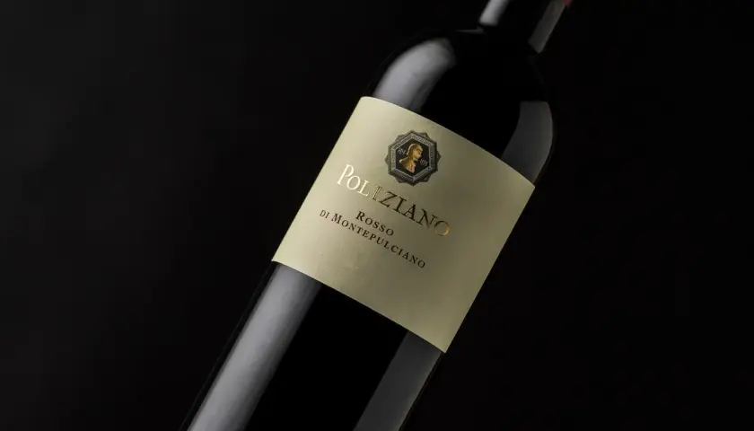 Bottiglia di vino rosso Poliziano, azienda agricola di Montepulciano, con etichetta color crema e scritte dorate.