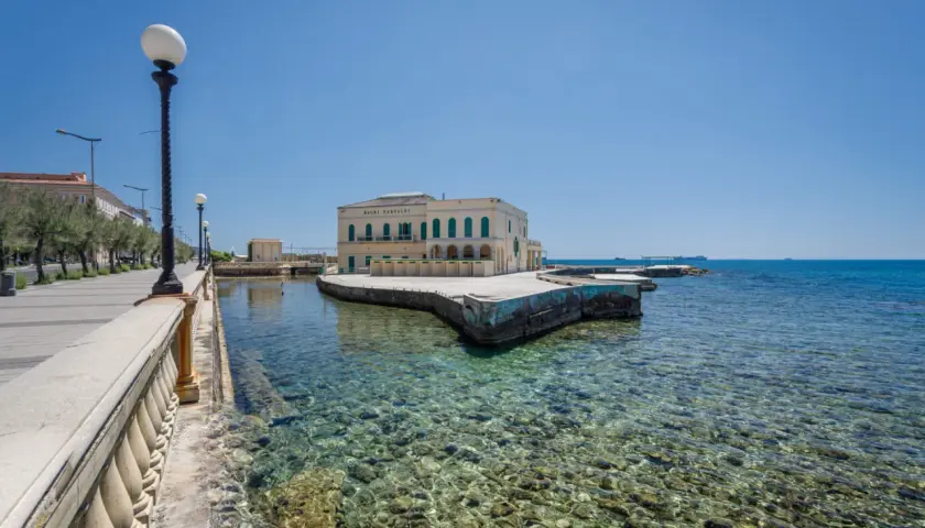 Il lungomare di Livorno con il Bagni Pasquali, un edificio giallo affacciato sul mare cristallino.