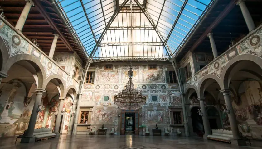 Interno di ville medicee visitabili con affreschi, un grande lampadario e tetto in vetro.